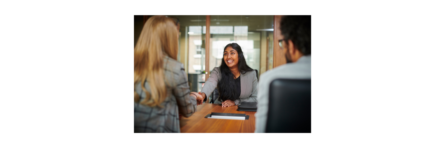 Women smiling with a handshake